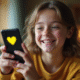 Jeune personne souriante avec smartphone affichant Snapchat et emoji cœur