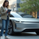 Jeune femme souriante devant voiture électrique autonome